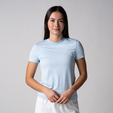 Gray background, female model wearing a JOOLA women's club short sleeve, blue breeze.