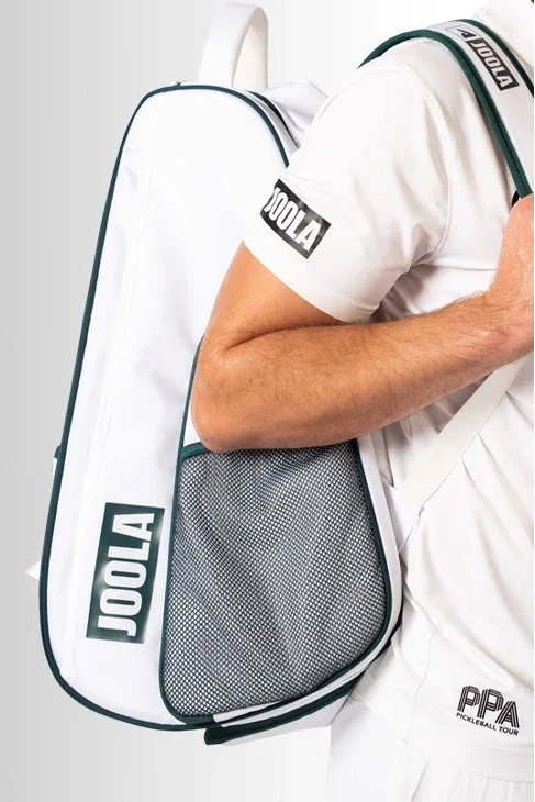 Person holding a JOOLA pickleball paddle bag against a gray background.