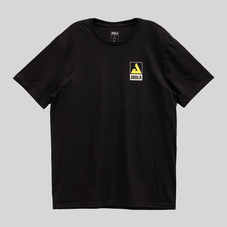 Gray background, black JOOLA t shirt with yellow trinity logo and JOOLA word mark over the left chest.
