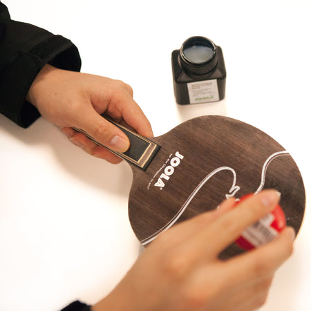 Close up image of hands do the Blade Sealing Service for table tennis rackets.