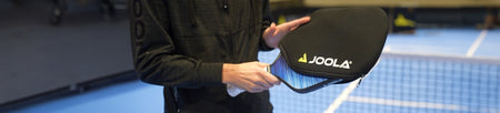 Banner image of someone holding a JOOLA paddle and putting it in a JOOLA paddle cover.