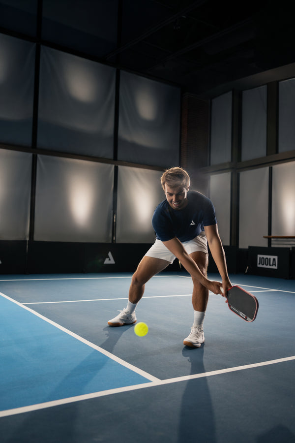 JOOLA Pro Ben Johns about to dig a pickleball off the court and return it using his Perseus Pro V.