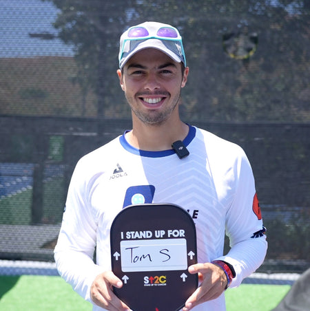 Ben Johns posing with customized Stand Up 2 cancer paddle.