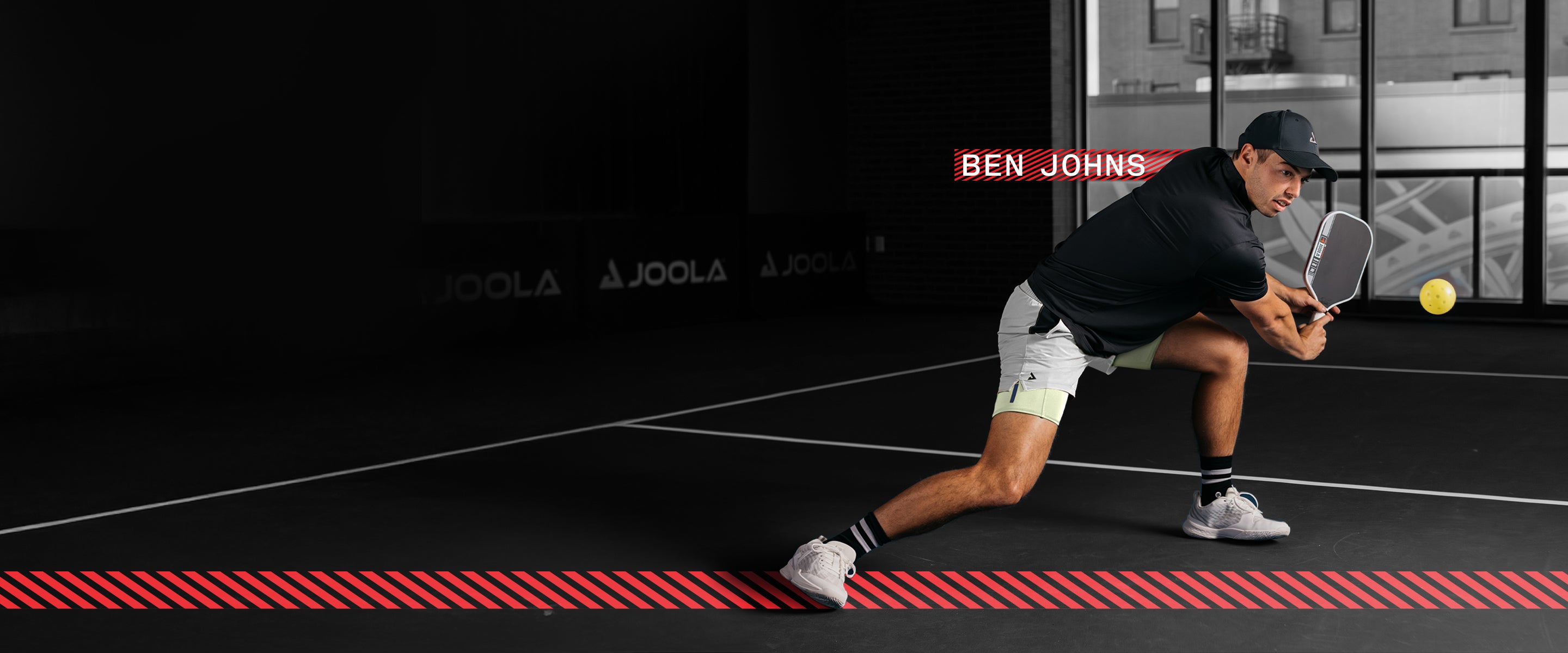 Horizontal banner image showing JOOLA pro Ben Johns playing pickleball at an indoor court.