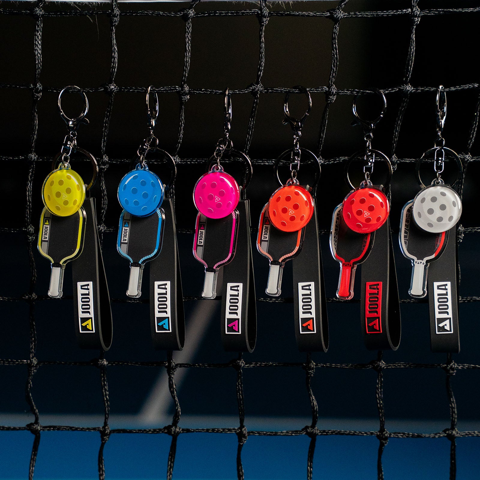 The full set of Agassi and Pro IV colorful table tennis paddle keychains on a black background.