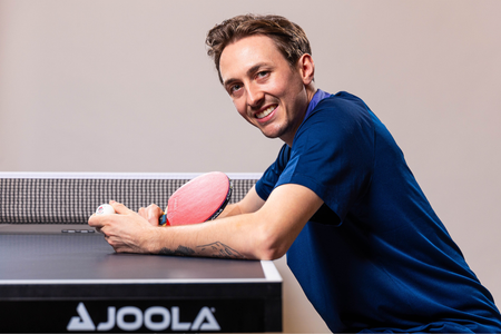 English Olympian Liam Pitchford Kneeling Beside the Table