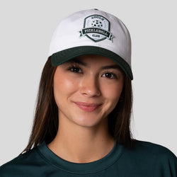 Women wearing a JOOLA Collegiate Cotton cap, white with green brim. Category
