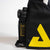 Black bag with a yellow logo and a black water bottle inside on a white background