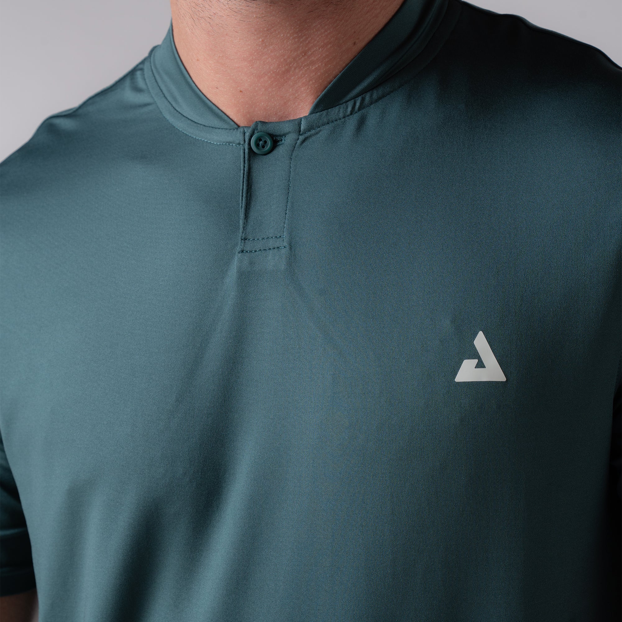 Product image of a club green colored JOOLA Men's Court Polo. JOOLA trinity logo is on the left side of the models chest. 