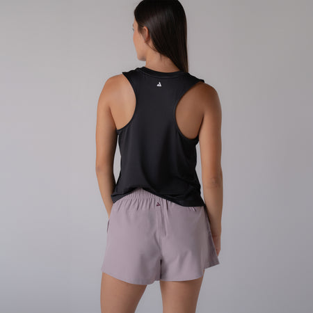 Image of a female model wearing a black JOOLA women's court tank top. The image is showing the back of the tank top.