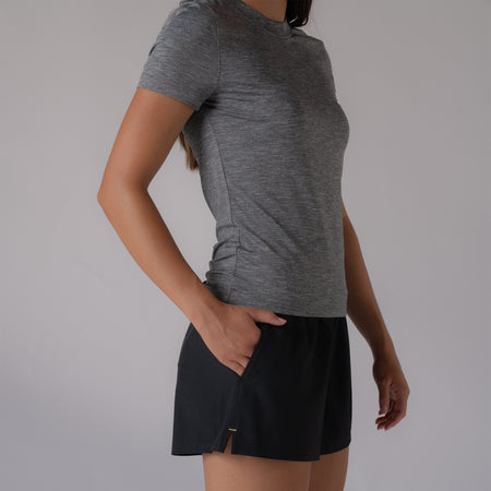 Image of a model with their hand in the pocket of a pair of black JOOLA women's woven shorts.