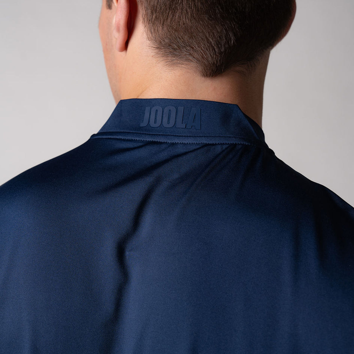 Close up image of the JOOLA logo across the back collar of the JOOLA Men's Court Polo, Navy.