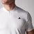 Close up image of a black JOOLA trinity logo over the left chest of a JOOLA male model wearing a Men's Court Polo, white.