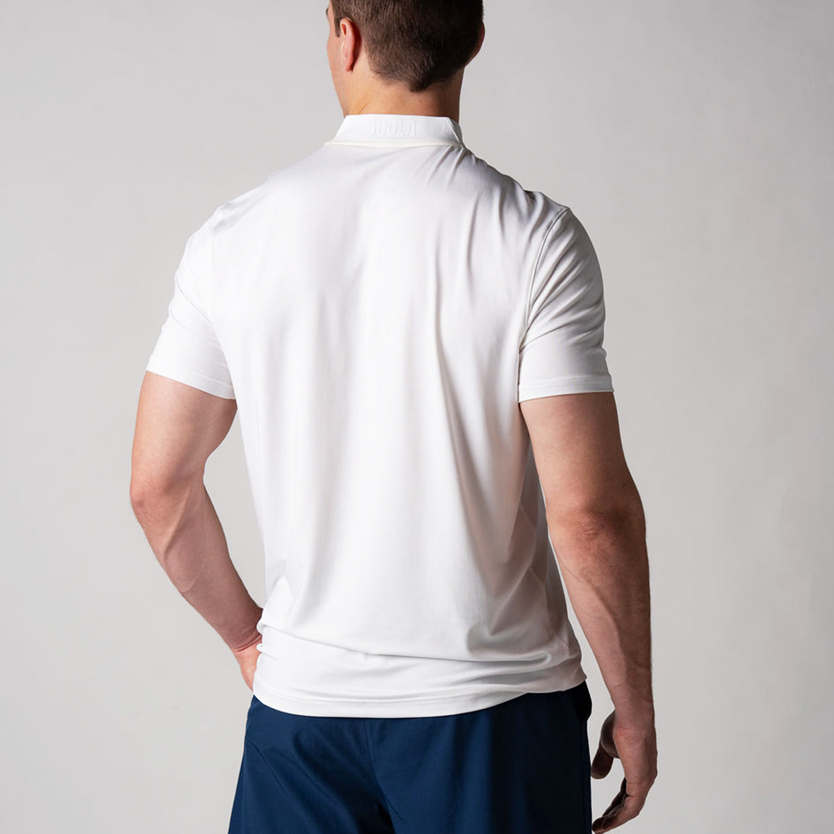 Image showing the back of a male model wearing a JOOLA men's court polo, white.