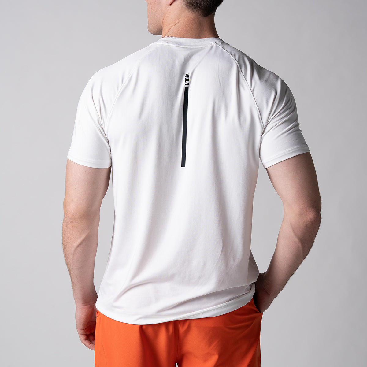 Image of a male model wearing a JOOLA Men's Court Short Sleeve shirt. The image shows the back of the shirt.