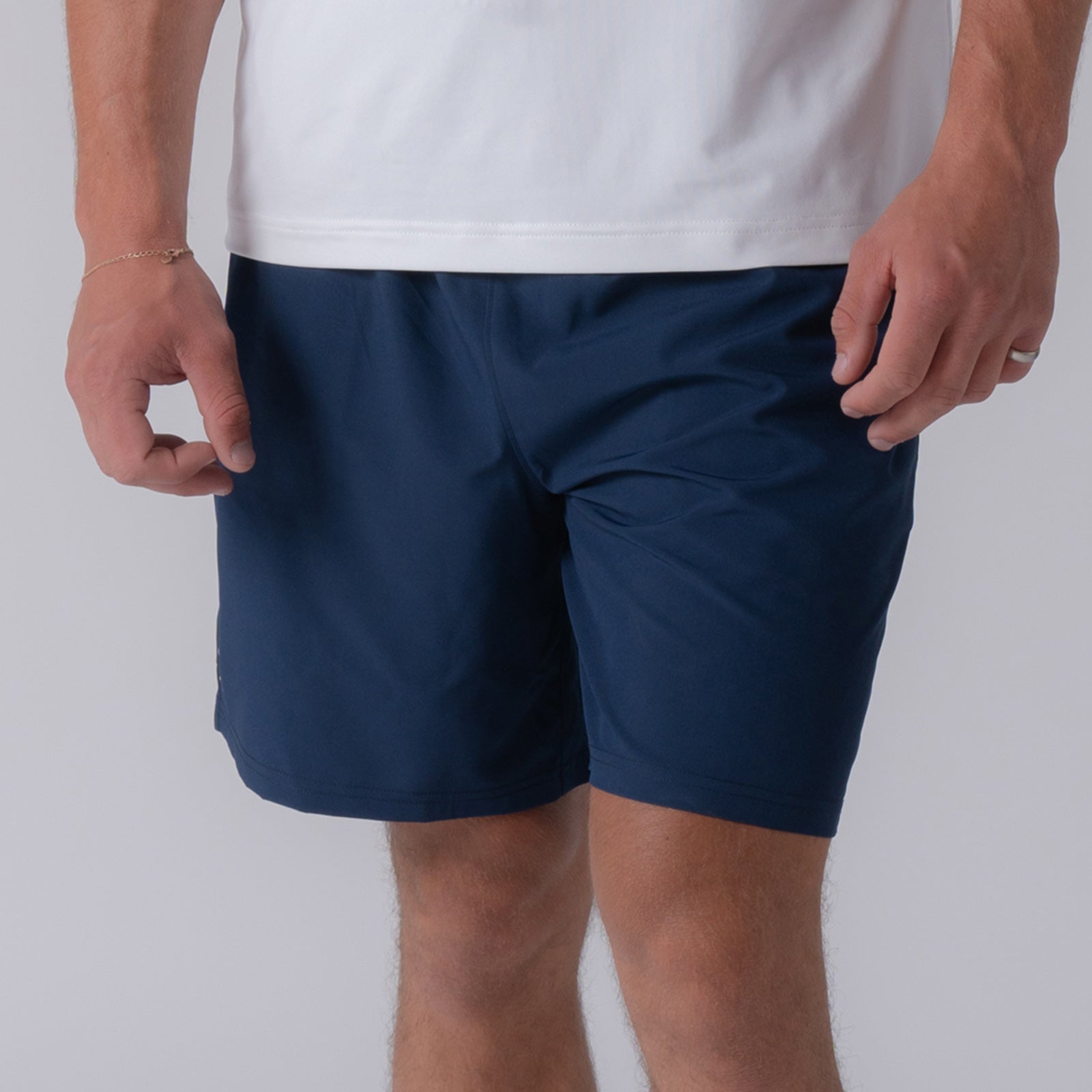 Close up image of a male model wearing a pair of JOOLA Men's Woven Shorts, 7-inch inseam, navy.