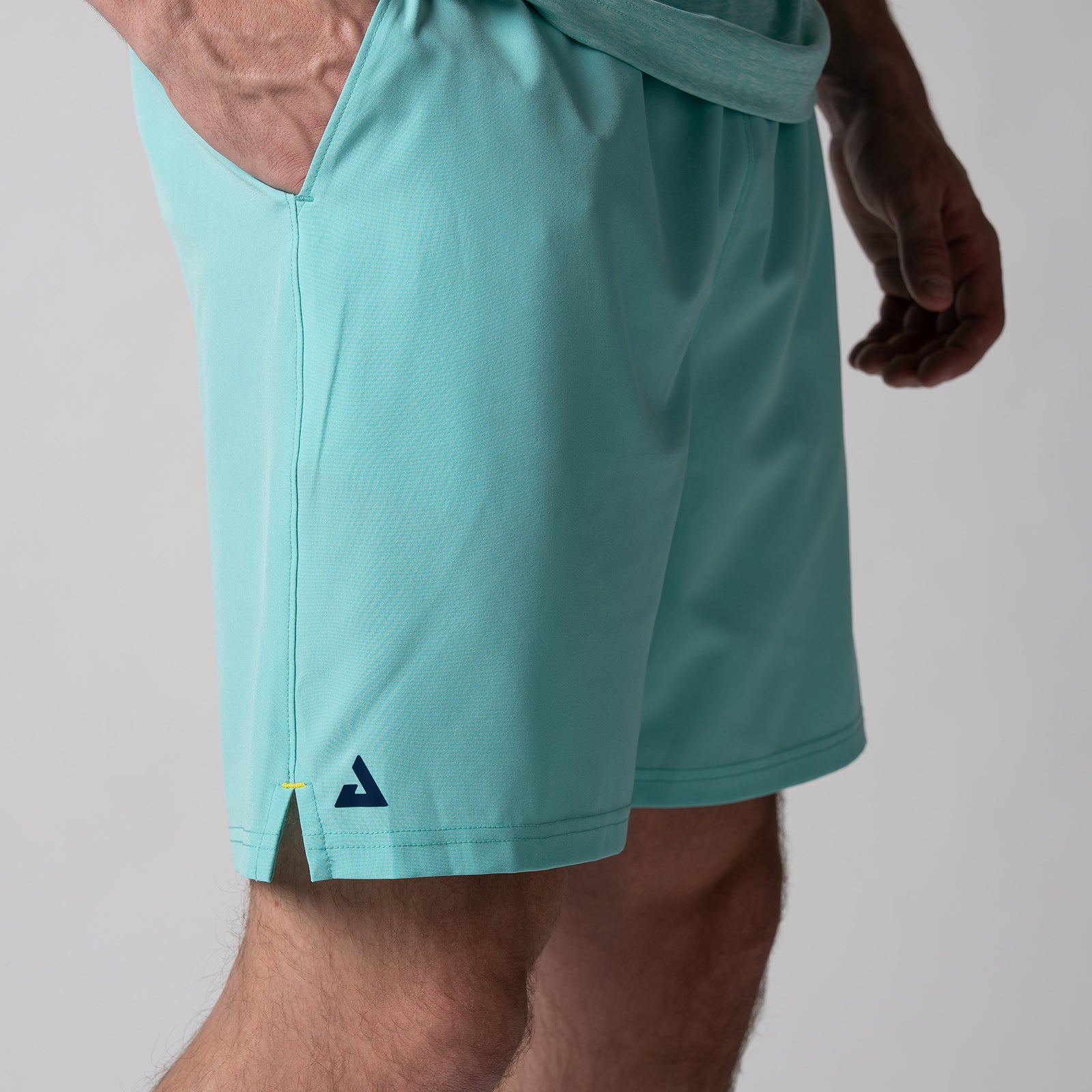 Close up image of the JOOLA trinity logo on the JOOLA Men's Woven Shorts, 7-inch, tropical tide.