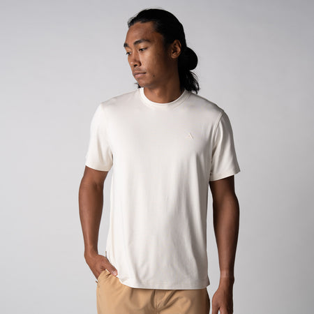 Gray background, image of a male model wearing a JOOLA Men's Club Short Sleeve shirt, sandstone color.