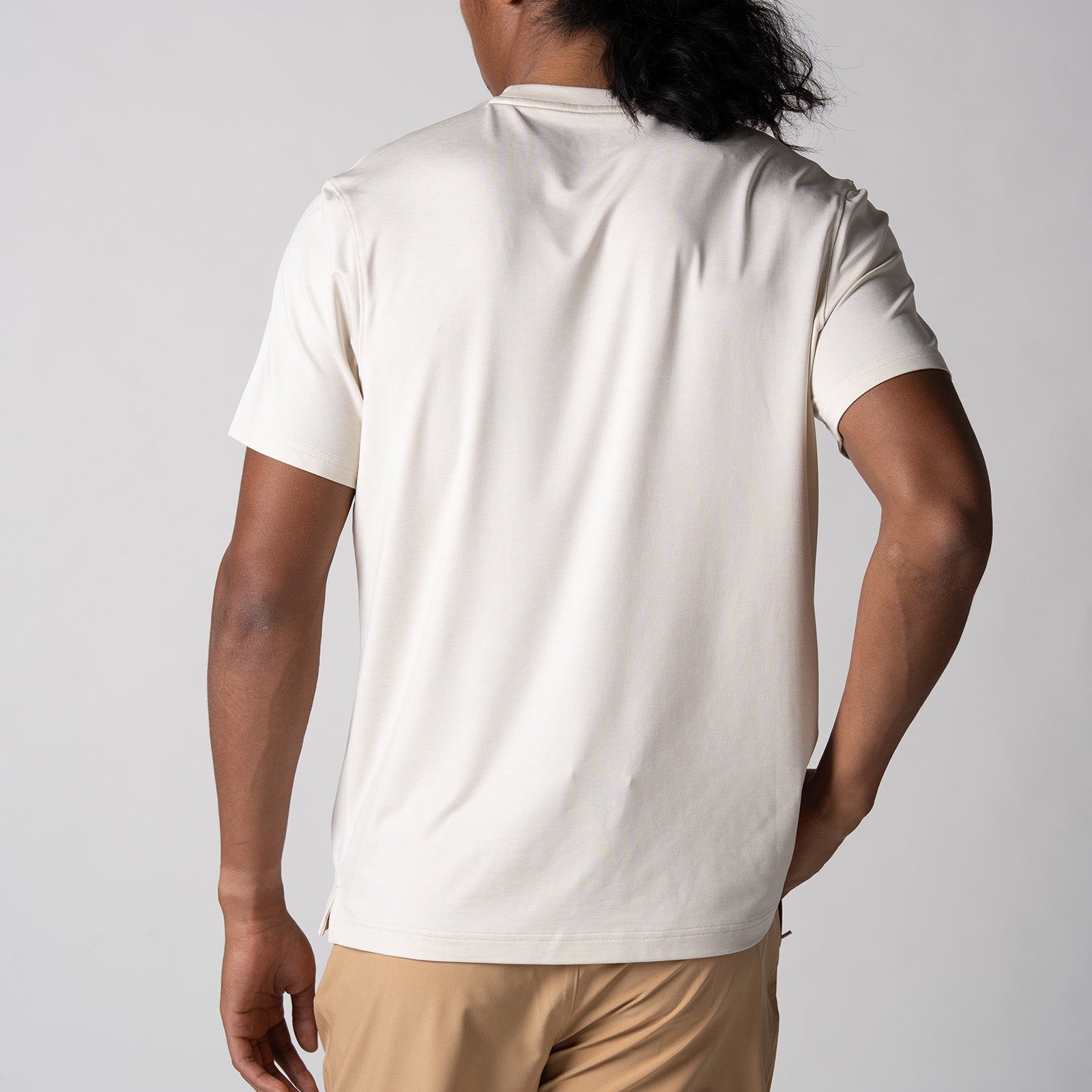 Gray background, image showing the back of a male model wearing a Men's Club Short Sleeve, Sandstone color.