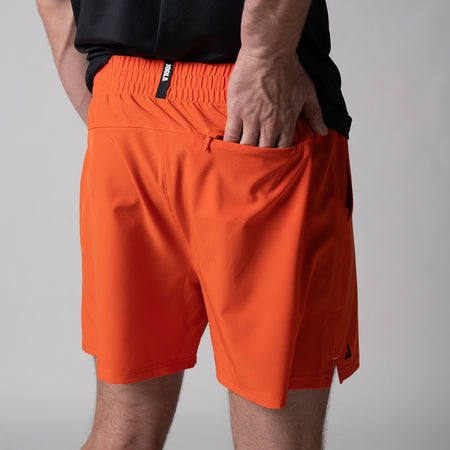Gray background, close up image of the back of a pair of JOOLA Men's Woven Shorts, 5-ich, poppy red color.