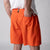 Gray background, close up image of the back of a male model who is wearing the JOOLA Men's Woven Shorts, 7-inch inseam, poppy red color.