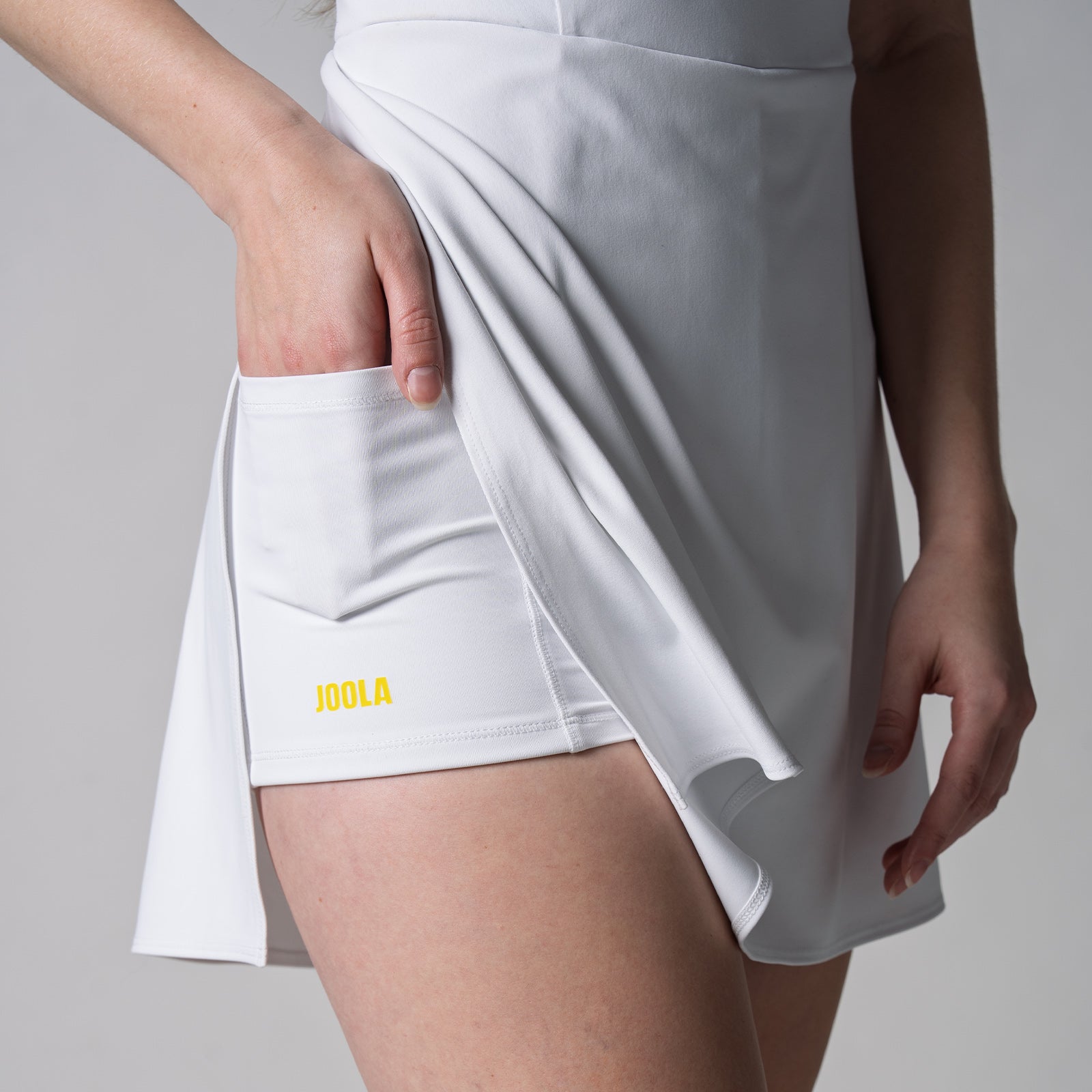 Close up image of the under pocket in the JOOLA Women's Court Racerback Dress, white.