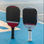 Image of the Agassi and Graf Edge pickleball paddles on a blue surfaced pickleball court.