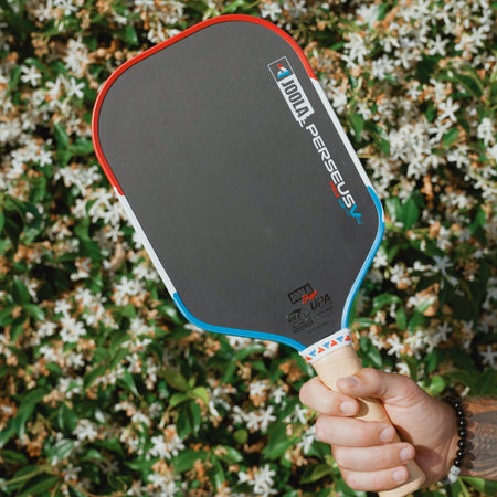 Man holding a JOOLA Perseus Pro V Rally Rocket pickleball paddle in his hand.