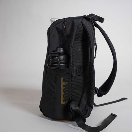 Black backpack with a water bottle in a pocket on a light gray background.