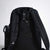Black JOOLA backpack with a water bottle holder on a light gray background