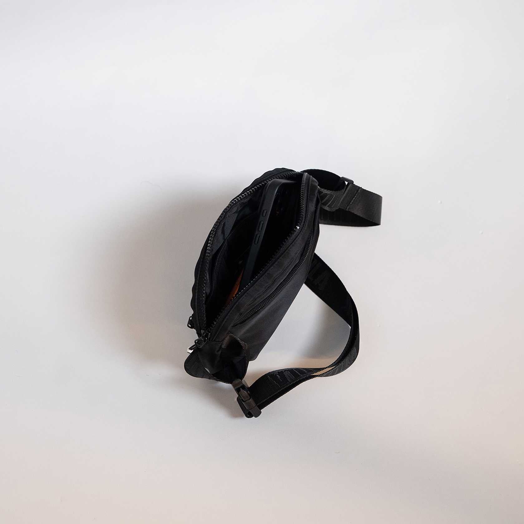 Black waist bag on a white background.