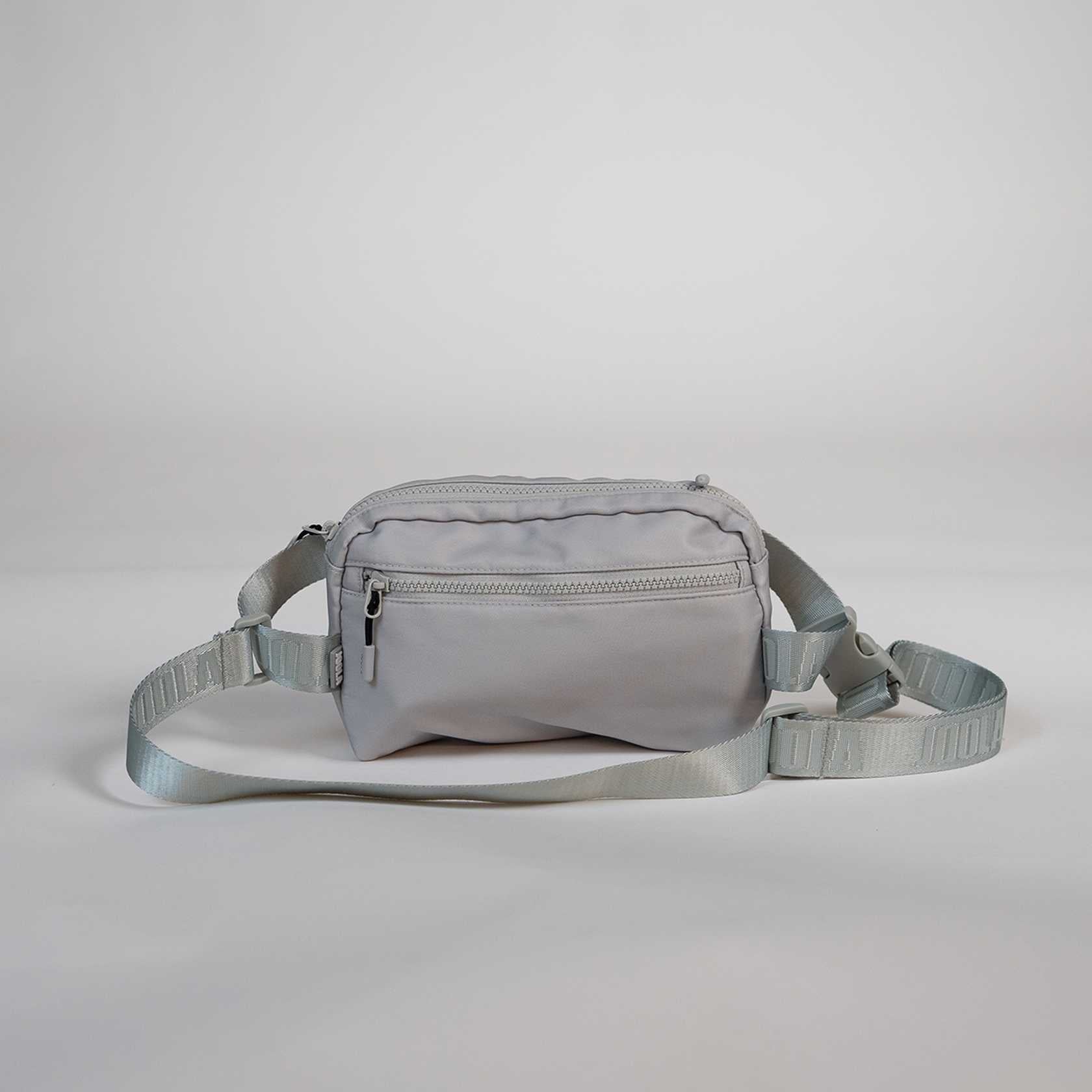 Gray waist bag with a strap on a light gray background.