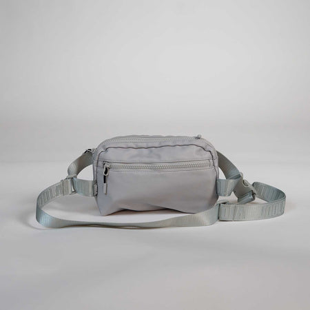 Gray waist bag with a strap on a light gray background.