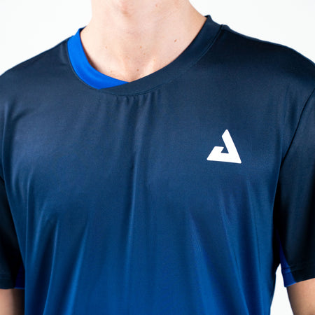 White background, close up on the white JOOLA Trinity Logo on a JOOLA Men's Competition Table Tennis shirt.