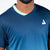 White background, product image showing a close up on the JOOLA Men's Competition table tennis shirt, half turqoisue and half blue.