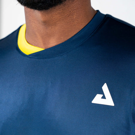 White background, close up on the yellow and blue neckline on a JOOLA Men's Competition table tennis shirt.
