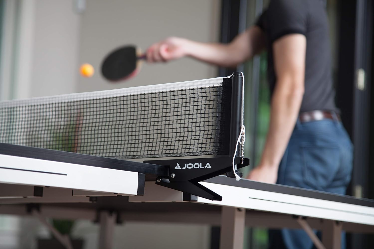 Close up image showing the net and posts of a JOOLA table tennis table.