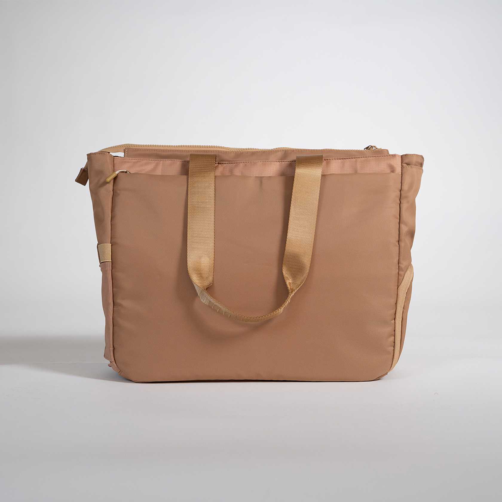 Brown tote bag with gold handles on a light gray background