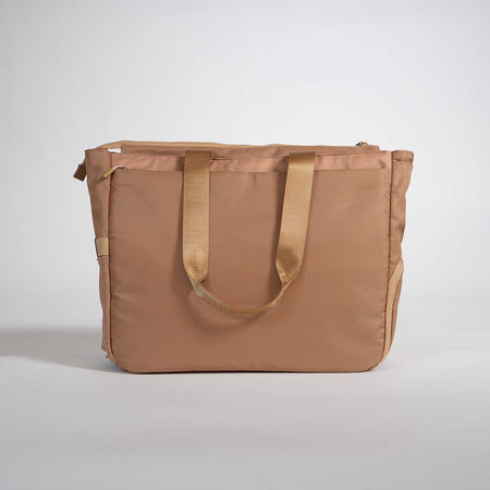 Brown tote bag with gold handles on a light gray background