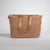 Brown tote bag with gold handles on a light gray background