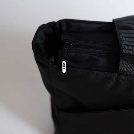 Close-up of a black JOOLA bag with a visible brand label on a light background