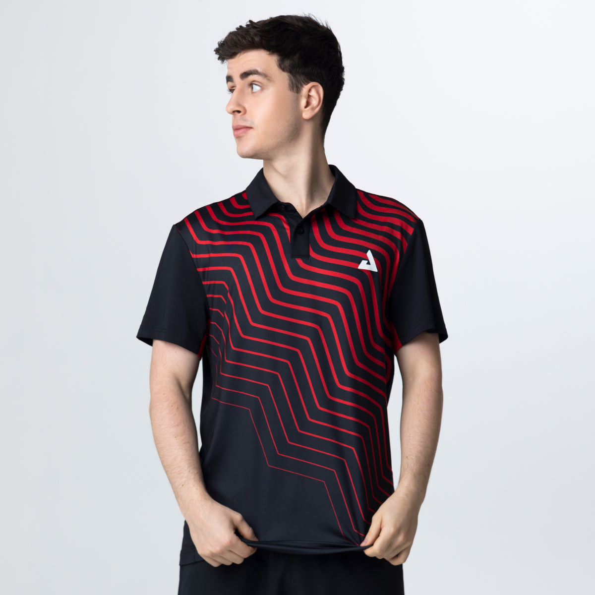 Person wearing a black and red patterned polo shirt on a light gray background