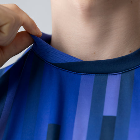 Close-up of a person wearing a blue JOOLA Table Tennis jersey.