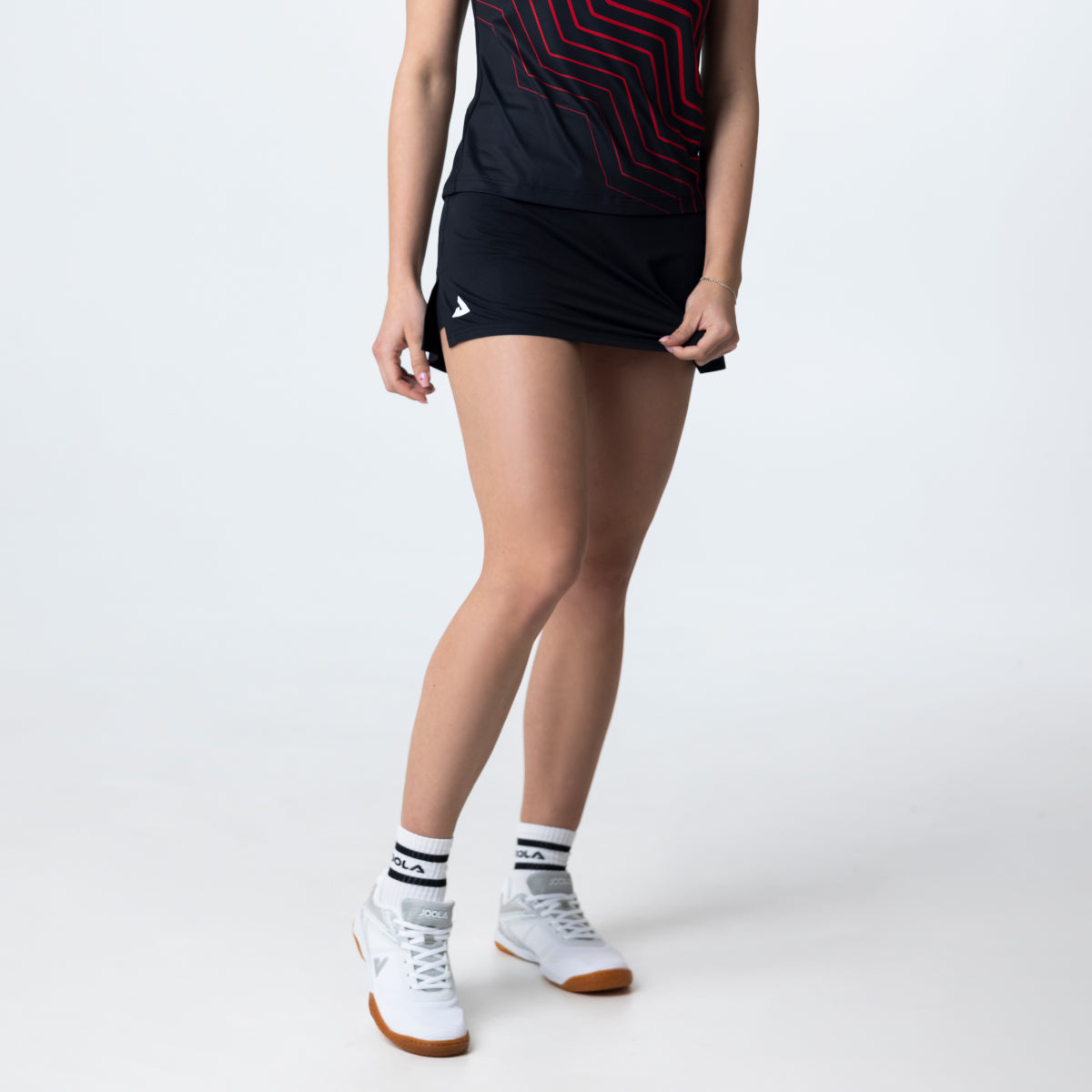 Gray background, image of the JOOLA Essential skirt in black and white.