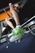 Image of JOOLA Table Tennis pro Hugo Calderano sitting on a table tennis table pointing towards the camera. Image highlights the JOOLA TT SM4SH Table Tennis shoe.