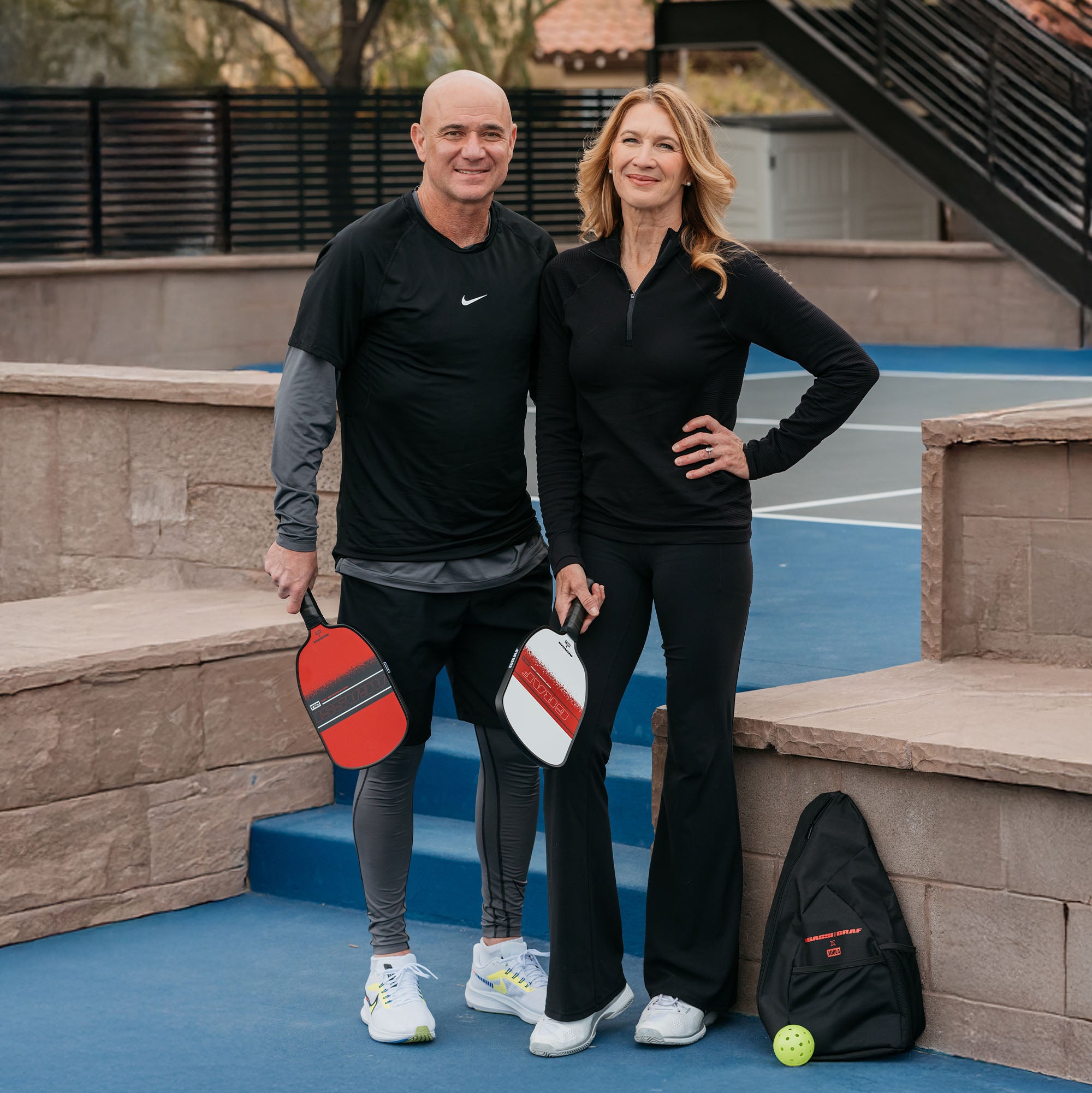 Image of tennis icons Andre Agassi and Steffi Graf posing with the new Agassi/Graf pickleball paddles.