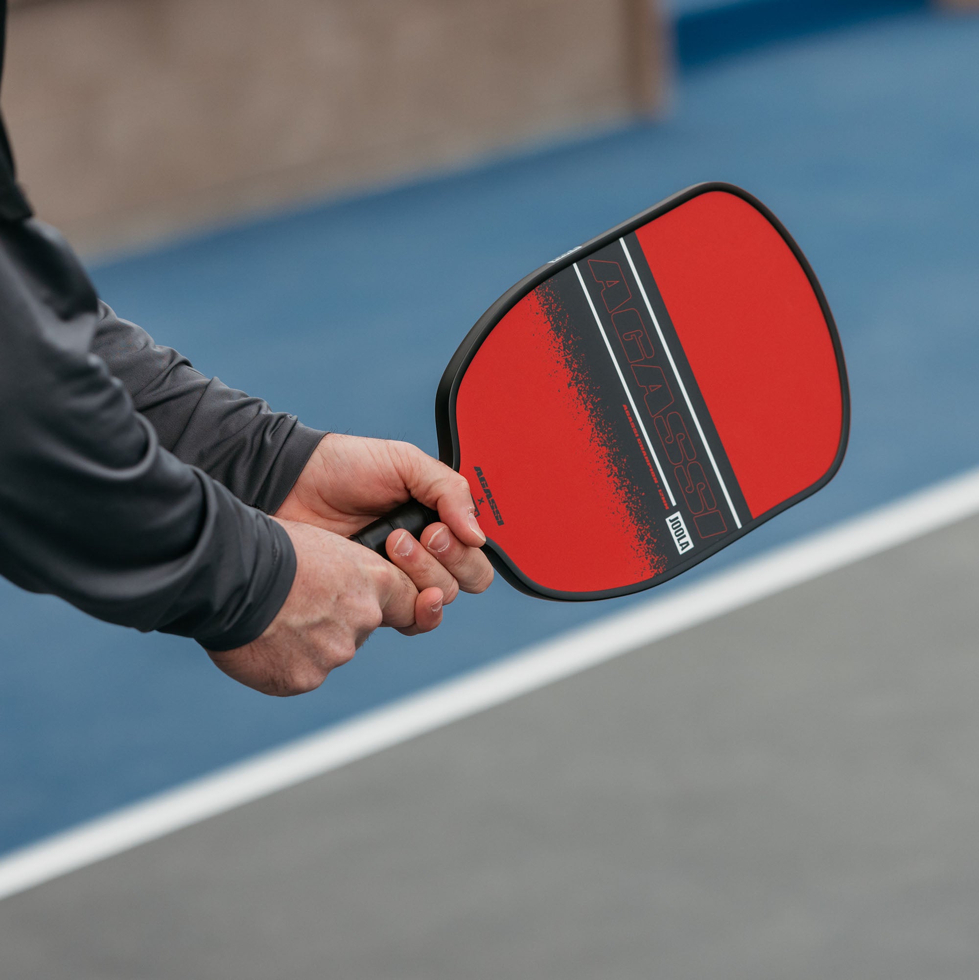 Close up web image of the Agassi x JOOLA pickleball paddle in Agassi's hand.