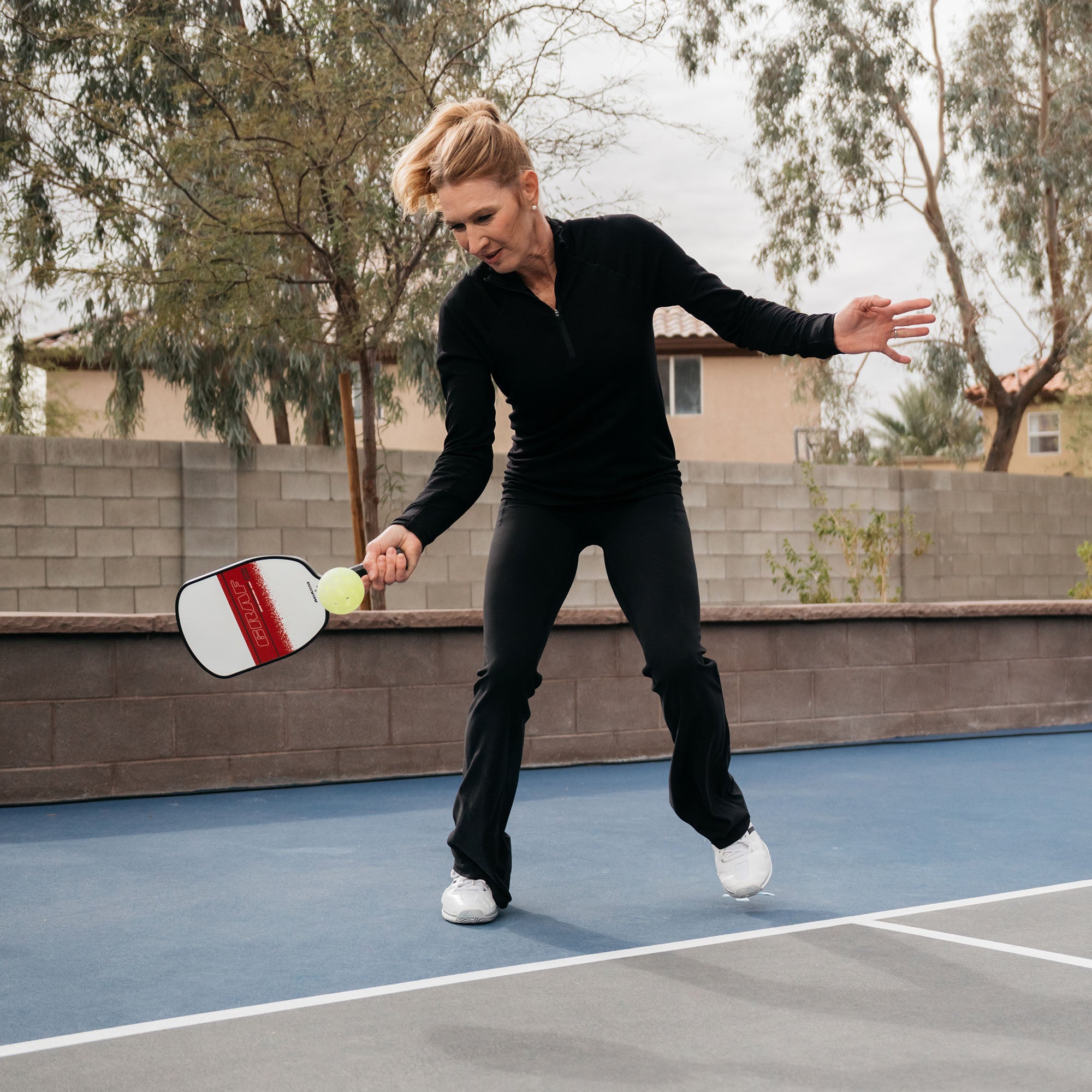 Close up image of Steffi Graf about to connect with a pickleball and holding her Graf x Agassi pickleball paddle.