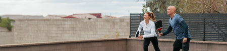 Horizontal banner image of Andre Agassi and Steffi Graf playing pickleball.