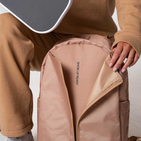 Close up on the 'Show Up Ready' tagline on the inside of the paddle compartment on the JOOLA Back pack. Latte.